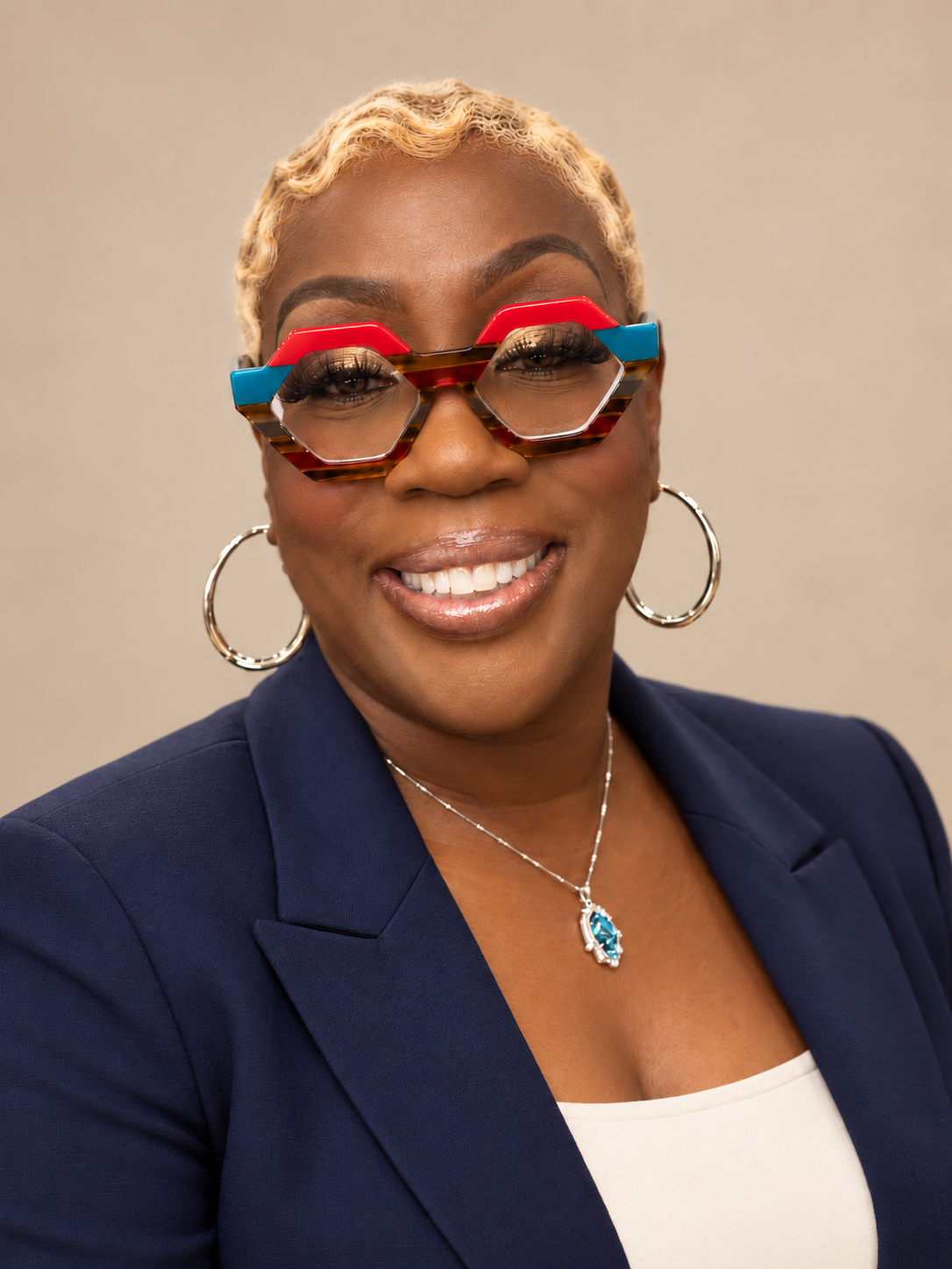 Lisa J. Harris smiling in a navy blazer and colorful glasses